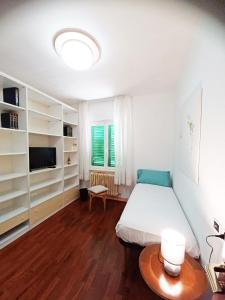 奇維塔諾瓦的住宿－Valentina Rooms，一间卧室配有一张床、一台电视和一张桌子