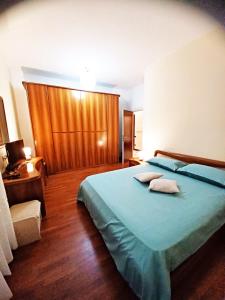 奇維塔諾瓦的住宿－Valentina Rooms，一间卧室配有蓝色的床和两个枕头