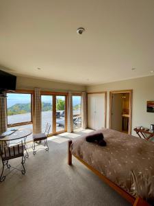 a bedroom with a bed and a table and chairs at Parautane Lodge in Nelson