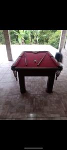 un tavolo da biliardo rosso, posto in cima a un patio di Chácara em Biritiba Mirim a Biritiba-Mirim