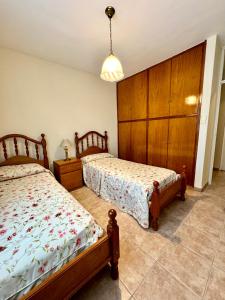 a bedroom with two beds and a cabinet at Departamento frente al Shopping ,B 8 in Guaymallen