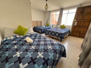 1 dormitorio con 2 camas y 2 mesas. en Casa Xibalba en Guatemala
