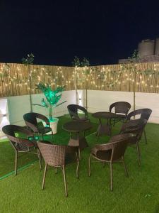 a group of chairs and tables on a lawn with lights at BoozyRoofs in New Delhi