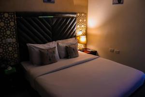una camera con letto con testata e lampada di Sunrise Pyramids View Inn a Il Cairo