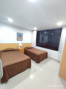 Habitación de hotel con 2 camas y ventana en Hotel Premier, en Tacna