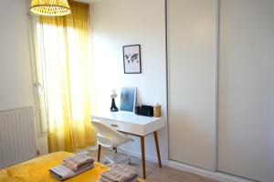 een slaapkamer met een bureau met een stoel en een bed bij Superbe appartement ,6 pers, proche de Paris, dans résidence privée , parking et WIFI gratuits! ! in Vitry-sur-Seine