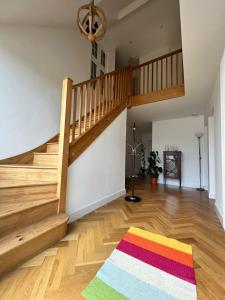 ein Wohnzimmer mit einer Treppe und einem bunten Teppich in der Unterkunft En-suites and Rooms Near Wembley Stadium in London