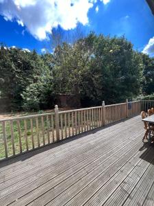 a wooden deck with a fence and a table at En-suites and Rooms Near Wembley Stadium in London