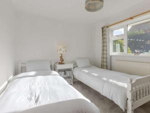Duas camas brancas num quarto com uma janela em 2 Bed in Bude 90312 em Bude