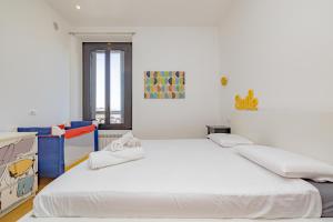 een witte kamer met 2 bedden en een raam bij Casa Navigli - Cozy Apartment in Milaan