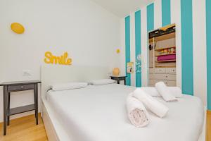 een slaapkamer met een wit bed en handdoeken bij Casa Navigli - Cozy Apartment in Milaan