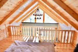 a bedroom of a wooden cabin with a chandelier at Cottage Kolašin in Kolašin