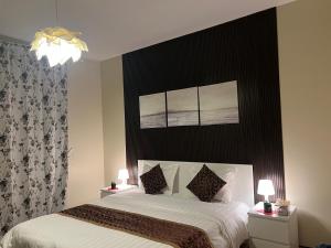 Schlafzimmer mit einem Bett mit einem schwarzen Kopfteil in der Unterkunft إطلالة بحرية عوائل فقط KAEC Star Sea View in King Abdullah Economic City