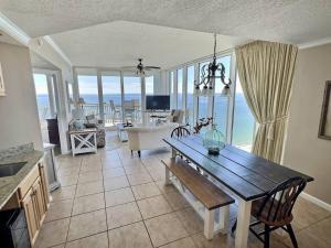 a living room with a table and a view of the ocean at 4 Bedroom Luxury High Rise Corner Condo with 2 Balconies, Heated Pool, Direct Beach Access in Gulf Shores