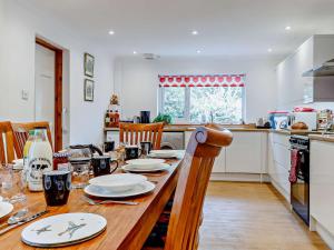 a kitchen with a wooden table with plates on it at 3 Bed in Welsh Newton Common 52149 in Welsh Newton Common