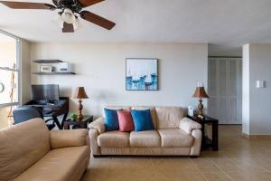 a living room with a couch and a ceiling fan at Adjust Your Latitude - Amazing Sea & Marina Views in Fajardo