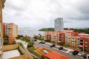 - une vue aérienne sur une ville avec des bâtiments et l'océan dans l'établissement Adjust Your Latitude - Amazing Sea & Marina Views, à Fajardo