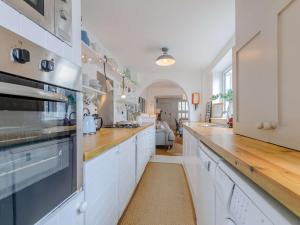 a kitchen with white cabinets and a wooden counter top at 3 Bed in Whitstable WCC20 in Whitstable