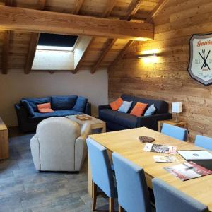 een woonkamer met een tafel en banken bij Les Chalets D'adrien - 3 Pièces pour 6 Personnes 74 in Valloire