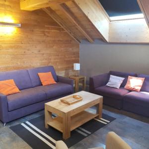 a living room with two purple couches and a coffee table at Les Chalets D'adrien - 3 Pièces pour 6 Personnes 84 in Valloire