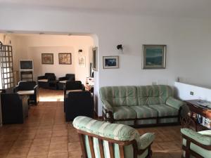 uma sala de estar com um sofá verde e cadeiras em Paco Residence Benessere & Relax em Ischia