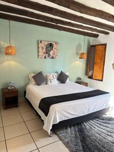 1 dormitorio con 1 cama grande con sábanas blancas en THIS IS COLOMBIA HOSTEL en San Gil