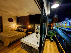 a bedroom with a bed and a bath tub next to a train at Habitacion Deluxe 2 con Jacuzzi a 20 mt del parque in Salento
