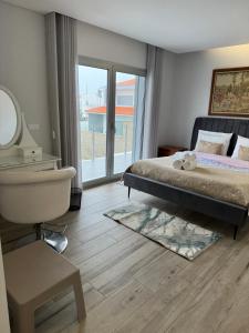 a bedroom with a bed and a bathroom with a window at MIRANDA HOUSE in Nazaré +33 photos
