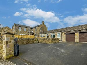 a brick house with a garage and a driveway at 5 Bed in Bingley 91977 in Bingley