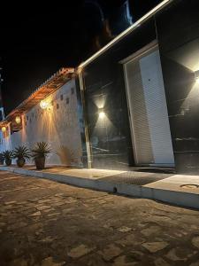 - un bâtiment avec une porte et une terrasse couverte la nuit dans l'établissement Chalé Betel, à Galinhos