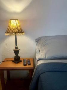 a lamp on a table next to a bed at Depto. Equipado, 1 Habitación con estacionamiento in Tulancingo