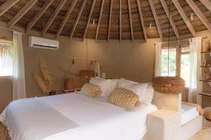 a bedroom with a white bed with two pillows at La Fragata in Vichayito