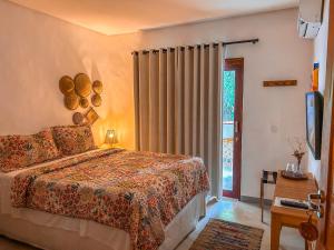 - une chambre avec un lit et une porte coulissante en verre dans l'établissement Maruê Guesthouse Porto de Pedras, à Porto de Pedras
