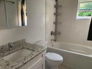 a bathroom with a sink and a toilet and a bath tub at Jackie's Guesthouse where memories are made 