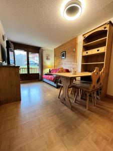 sala de estar con mesa y cama en Les Chalets Des Evettes - 2 Pièces pour 4 Personnes 94 en Notre-Dame-de-Bellecombe