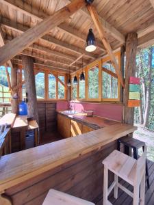 - une cuisine dans une cabane en rondins avec une grande table en bois dans l'établissement Casa na árvore perto da praia, à Imaruí