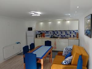 a kitchen with a table and blue chairs in a room at Apartament Alias in Ustroń