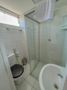 a bathroom with a toilet and a glass shower at Hotel América Praia in Recife