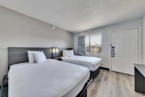 two white beds in a room with a window at Motel 6-Austin, TX - South - Airport in Austin