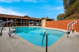 - une piscine avec 2 chaises à côté d'une clôture dans l'établissement Best Western Willits Inn, à Willits