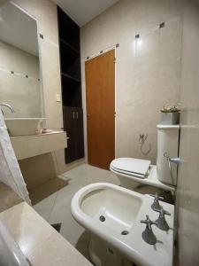a white bathroom with a sink and a toilet at Acordes de Chacras in Chacras de Coria +33 photos