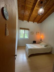 a bedroom with a bed and a wooden ceiling at Acordes de Chacras in Chacras de Coria