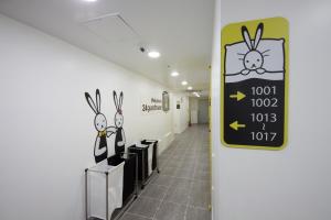 a hallway with a sign with rabbits on the wall at 24 Guesthouse Myeongdong Town in Seoul