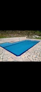una piscina con acqua blu su un pavimento in pietra di Chácara em Biritiba Mirim 2 a Biritiba-Mirim