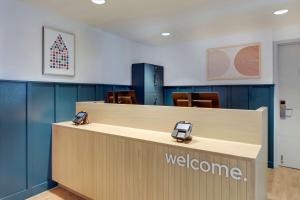 a welcome counter in a waiting room with a christmas tree at Sonesta Simply Suites Miami Airport Doral in Miami