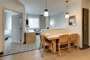 a dining room and living room with a table and chairs at Sonesta Simply Suites Miami Airport Doral in Miami