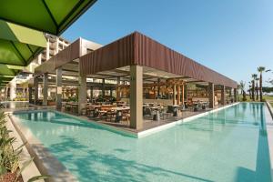a swimming pool in a resort with a restaurant at Cullinan Belek in Belek