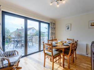 a dining room with a table and chairs and a large window at 3 Bed in Swanage 79405 in Swanage