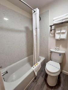 ein Badezimmer mit Toilette und Badewanne in der Unterkunft Howard Johnson by Wyndham Downtown Reno in Reno