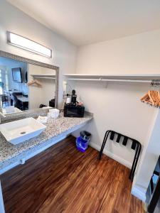 Zimmer mit einer Theke mit einem Waschbecken und einem Spiegel in der Unterkunft Howard Johnson by Wyndham Downtown Reno in Reno